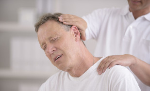 Un home con osteocondrose do pescozo nunha consulta cun masaxista manual
